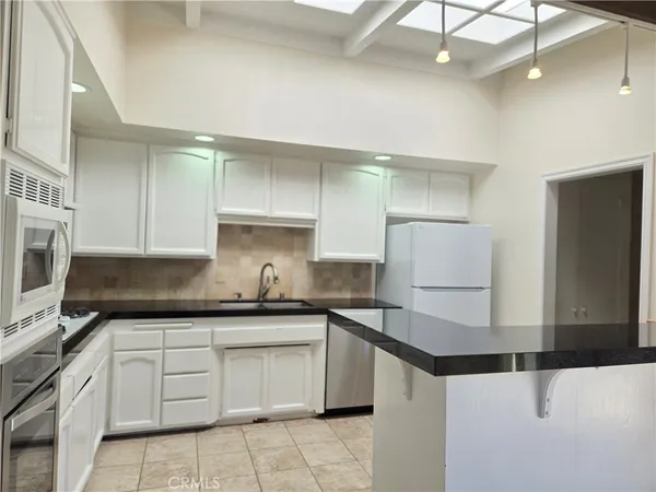 a kitchen with a sink a stove and cabinets