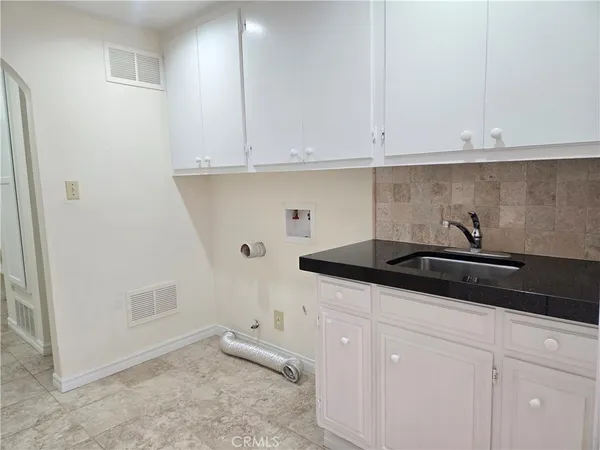 a kitchen with granite countertop white cabinets and white appliances