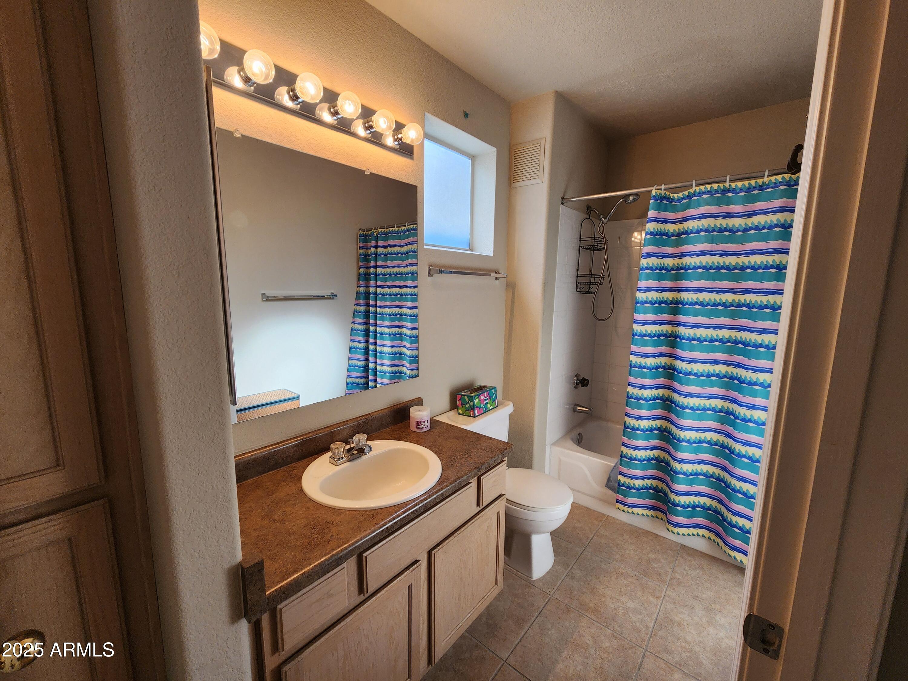 3848 North 3rd Avenue, Unit 1044 Phoenix, AZ 85013 - Photo 10 of 22 a bathroom with a sink a toilet a mirror and shower curtain