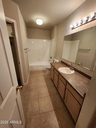 a bathroom with a granite countertop sink a toilet a mirror and vanity