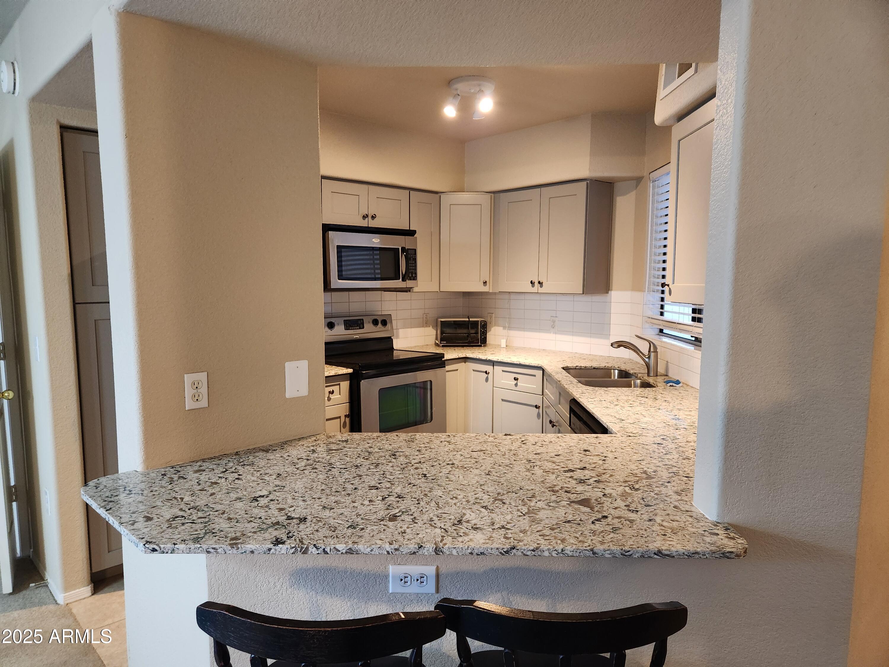 3848 North 3rd Avenue, Unit 1044 Phoenix, AZ 85013 - Photo 2 of 22 a kitchen with stainless steel appliances granite countertop a sink stove and refrigerator