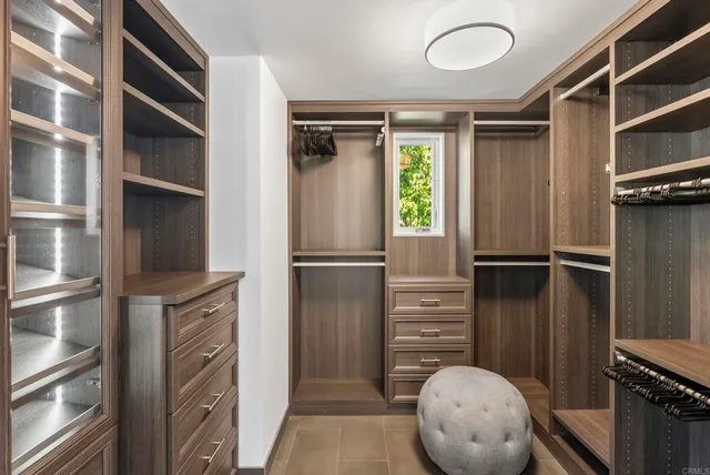 a view of walk in closet with clothes and shoes