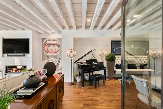 a living room with furniture a flat screen tv and kitchen view