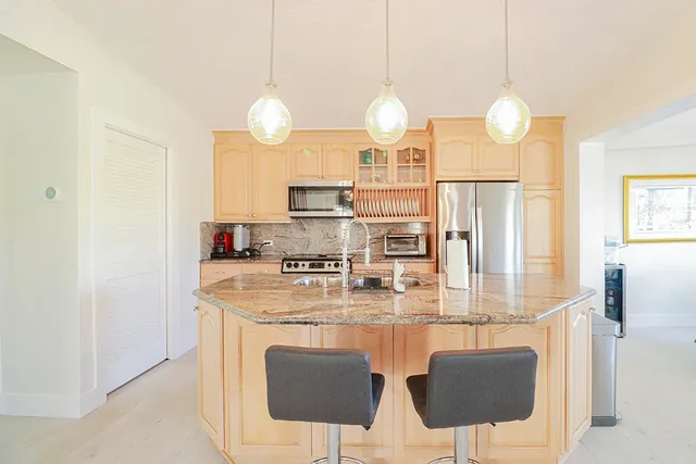 a kitchen with stainless steel appliances granite countertop a sink a stove and a refrigerator