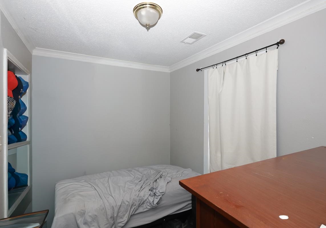 1023 Parkland Road Memphis, TN 38111 - Photo 9 of 13 a bedroom with a bed and a chandelier