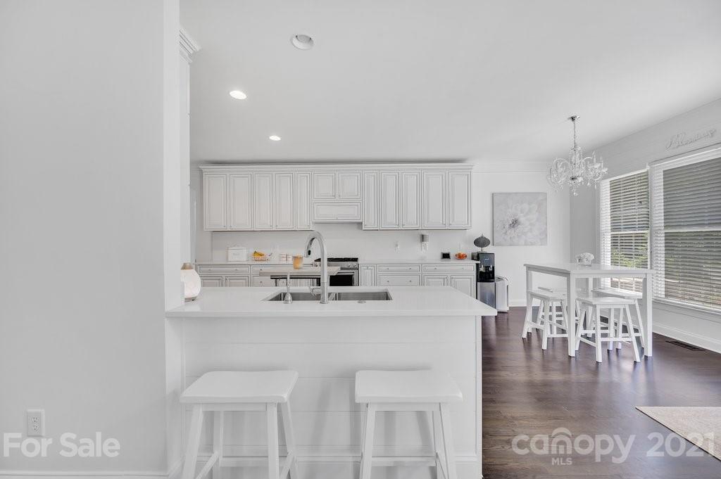 1883 Chestnut Hill Drive Tega Cay, SC 29708 - Photo 12 of 34 a kitchen with stainless steel appliances granite countertop a stove a sink a dining table and chairs