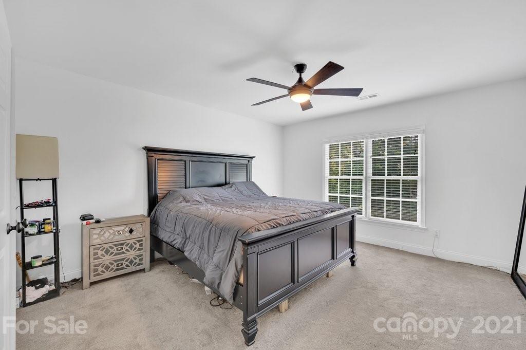 1883 Chestnut Hill Drive Tega Cay, SC 29708 - Photo 20 of 34 a spacious bedroom with a large bed and a chandelier