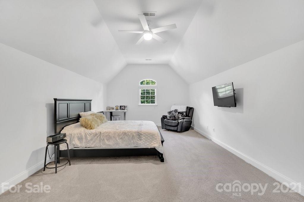 1883 Chestnut Hill Drive Tega Cay, SC 29708 - Photo 22 of 34 a spacious bedroom with a bed and a chandelier