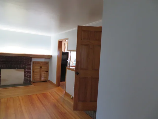 a view of a hallway with wooden floor and closet area