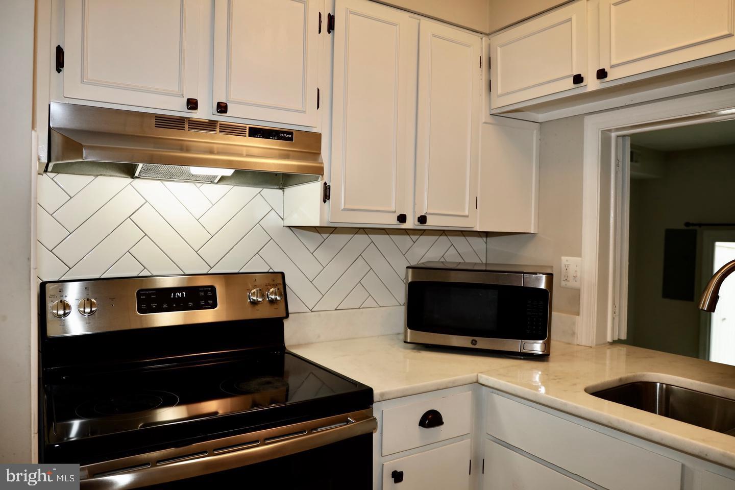 5918 Prince George Drive, Unit 313 Springfield, VA 22152 - Photo 11 of 29 a kitchen with stainless steel appliances a stove and a microwave