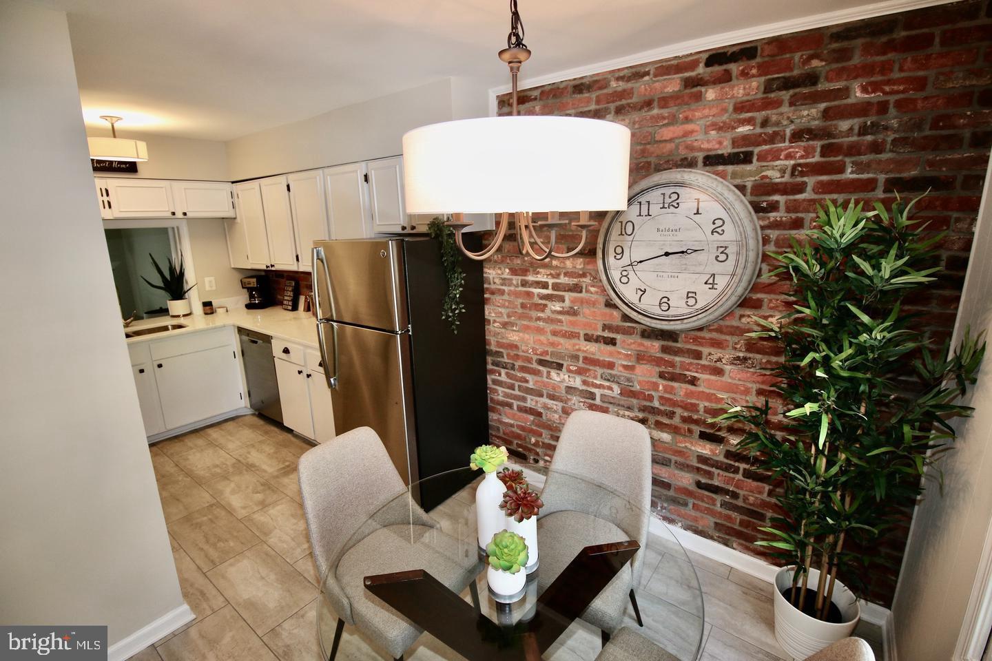 5918 Prince George Drive, Unit 313 Springfield, VA 22152 - Photo 3 of 29 a living room with furniture a wall clock and a potted plant