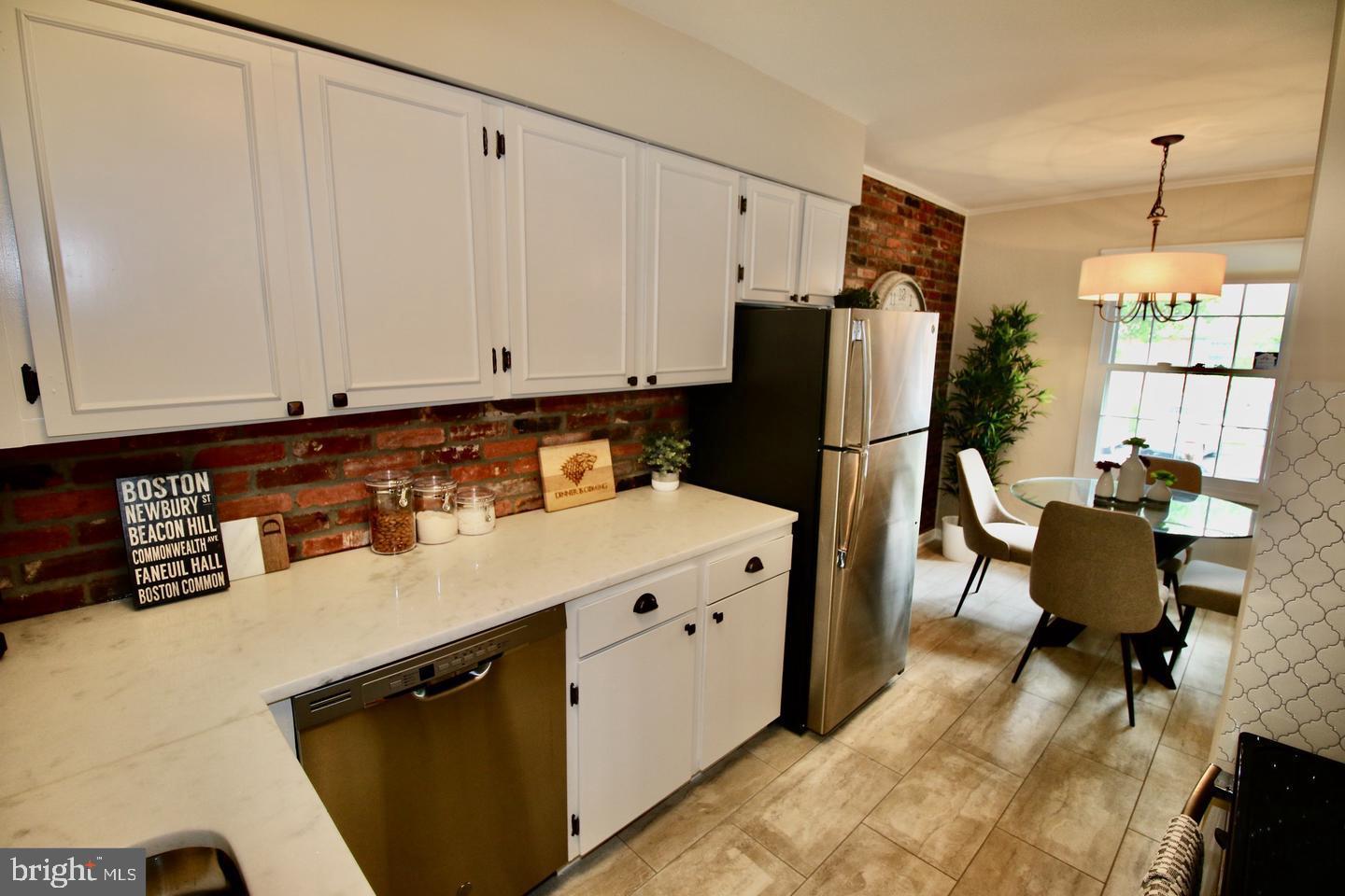 5918 Prince George Drive, Unit 313 Springfield, VA 22152 - Photo 7 of 29 a kitchen with stainless steel appliances granite countertop a refrigerator a sink dishwasher a stove with white cabinets