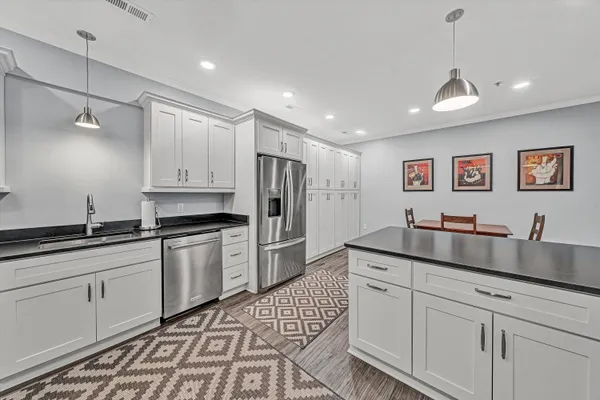 a kitchen with granite countertop white cabinets and stainless steel appliances