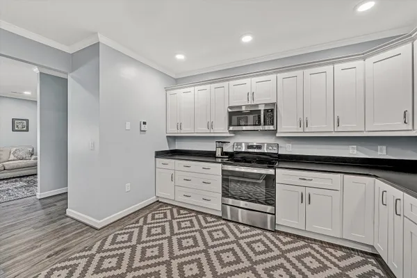 a kitchen with granite countertop a refrigerator and a sink