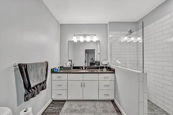 a bathroom with a granite countertop sink a shower and a mirror