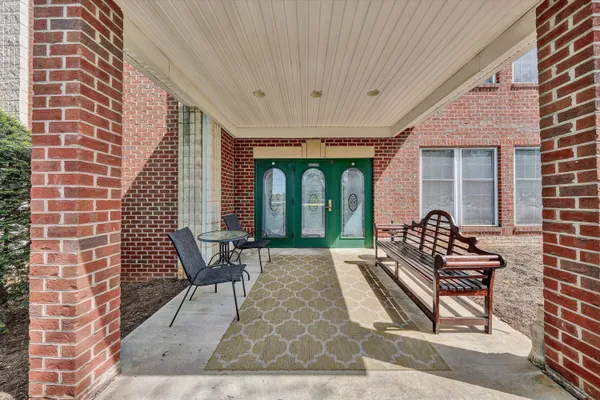 a view of a hallway with a cabinet door and wooden floor