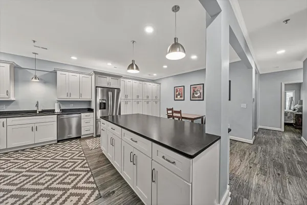 a kitchen with granite countertop white cabinets stainless steel appliances and a sink