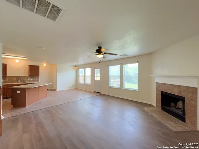 a view of an empty room with a fireplace and a window