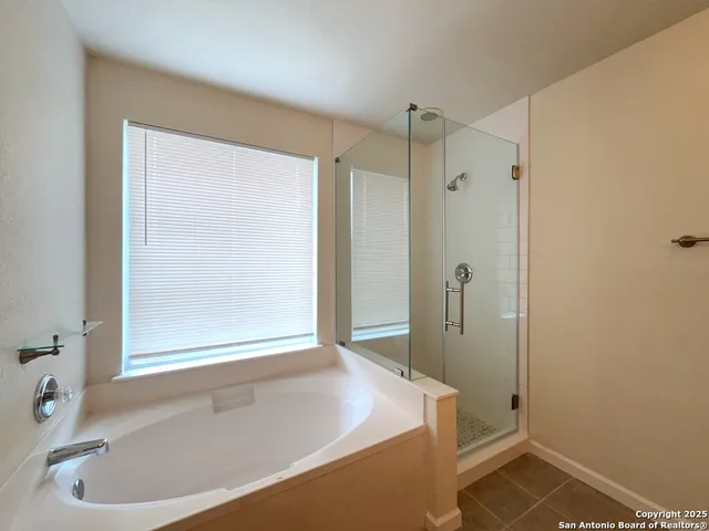 an empty room with wooden floor ceiling fan and windows