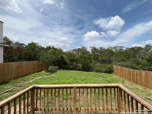 a view of a balcony with wooden floor and fence