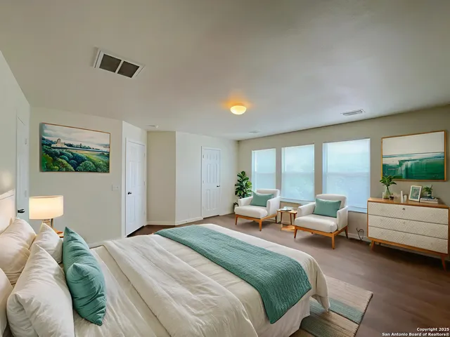 a bedroom with a bed and large windows