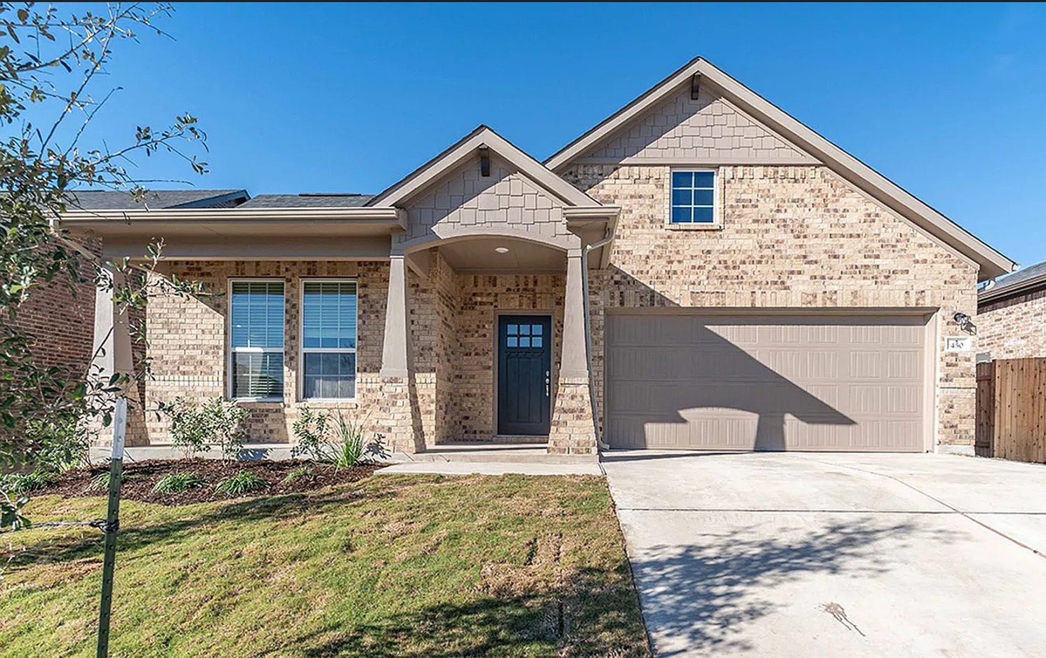 A welcoming facade showcases brick and shake siding, complemented by a convenient attached garage.
