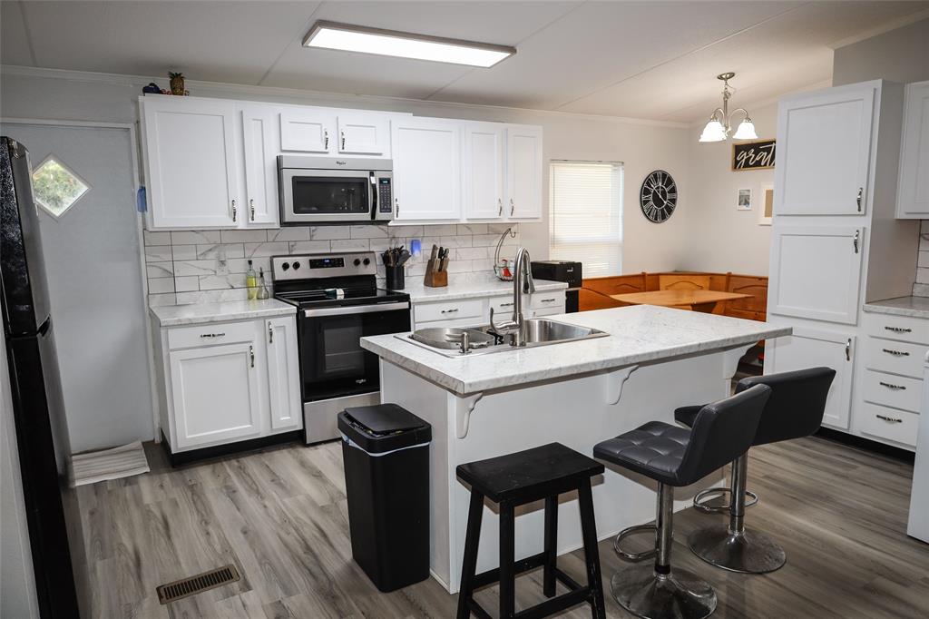 214 Destiny Lane Keatchie, LA 71046 - Photo 12 of 40 a white kitchen with a sink cabinets and wooden floor