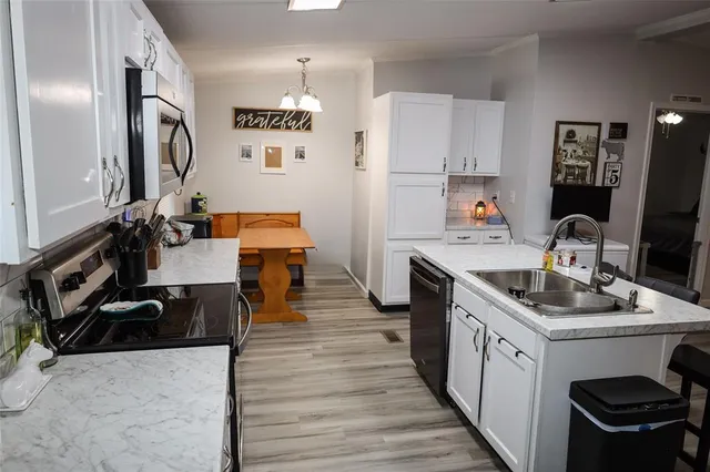 a kitchen with granite countertop a sink stove and cabinets