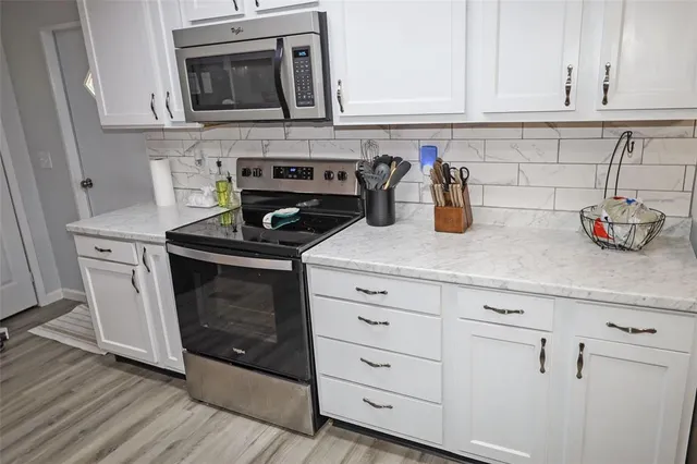a kitchen with stainless steel appliances granite countertop a sink a stove and cabinets