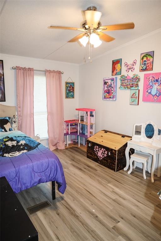 214 Destiny Lane Keatchie, LA 71046 - Photo 25 of 40 a spacious bedroom with a bed a dresser and wooden floor