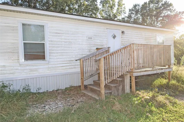 a view of a house with backyard and trees