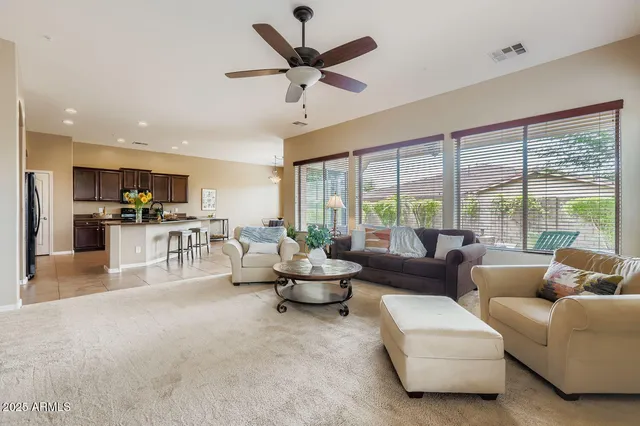 a living room with furniture and a large window with kitchen view