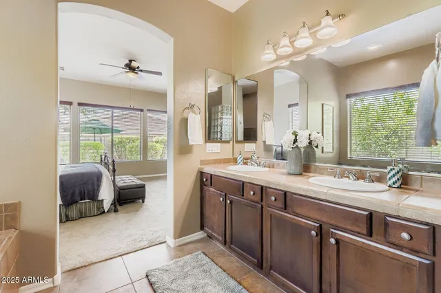 a spacious bathroom with a double vanity sink a mirror and a shower