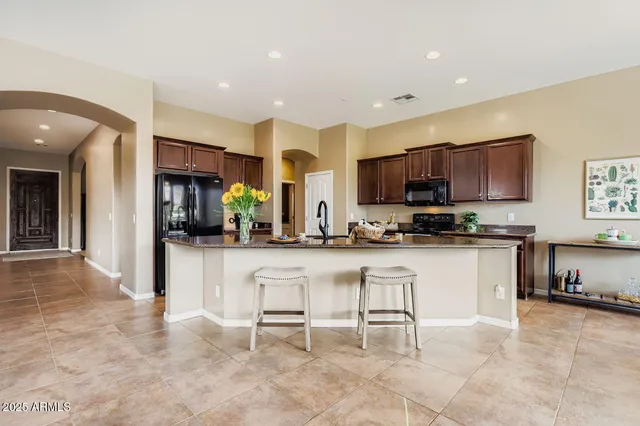 a kitchen with stainless steel appliances granite countertop a refrigerator and a stove top oven