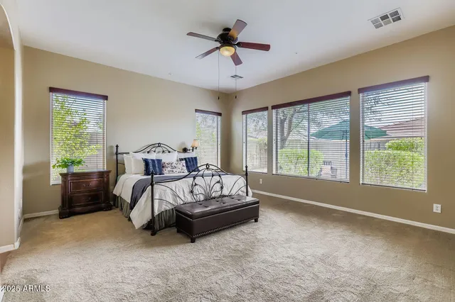 a spacious bedroom with a bed and a large window