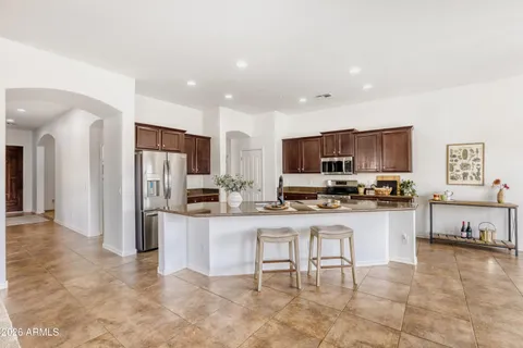 a kitchen with stainless steel appliances kitchen island granite countertop a refrigerator and microwave