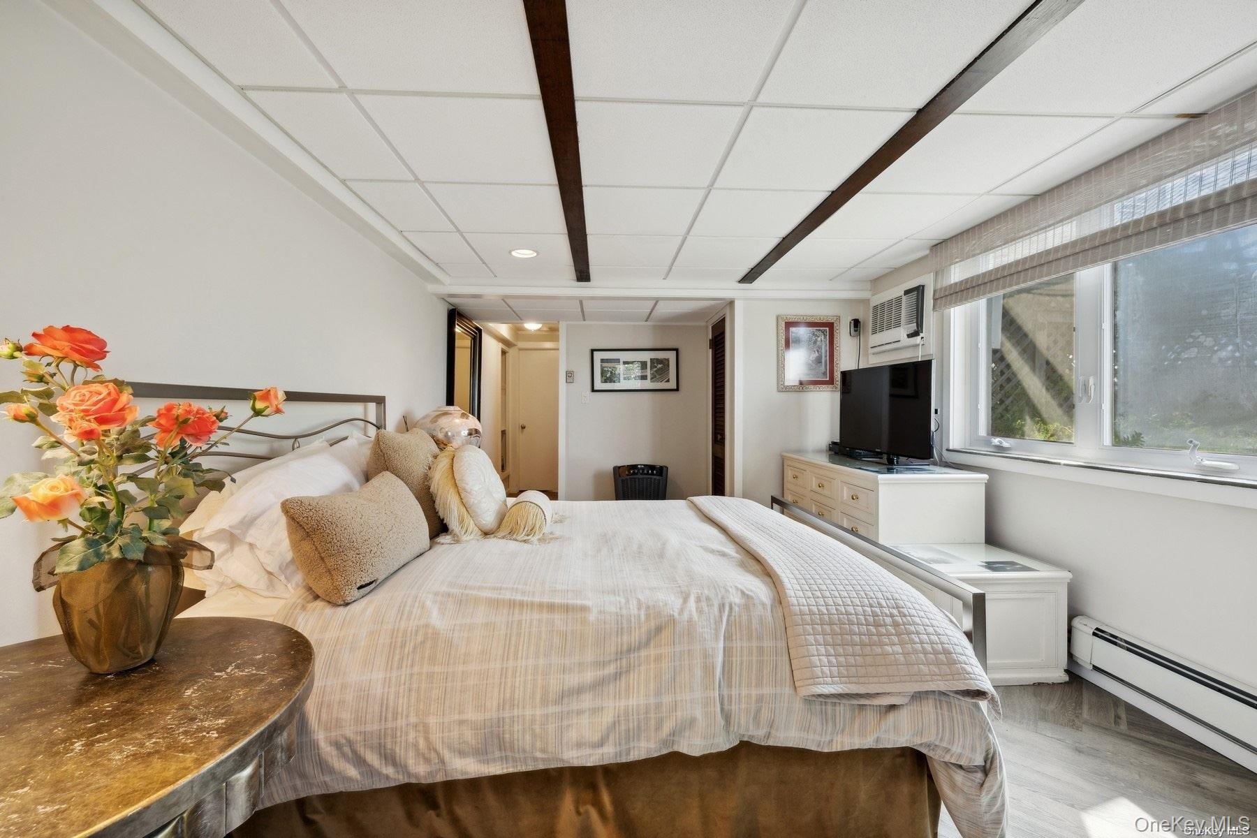 2 West Hillover Road Hampton Bays, NY 11946 - Photo 18 of 42 a bedroom with a bed and wooden floor