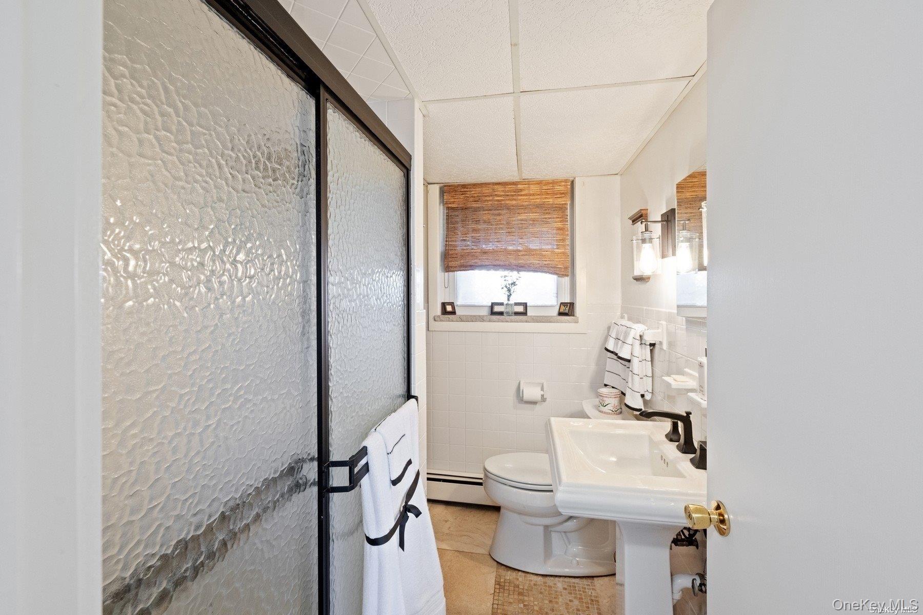 2 West Hillover Road Hampton Bays, NY 11946 - Photo 21 of 42 a bathroom with a toilet sink and shower