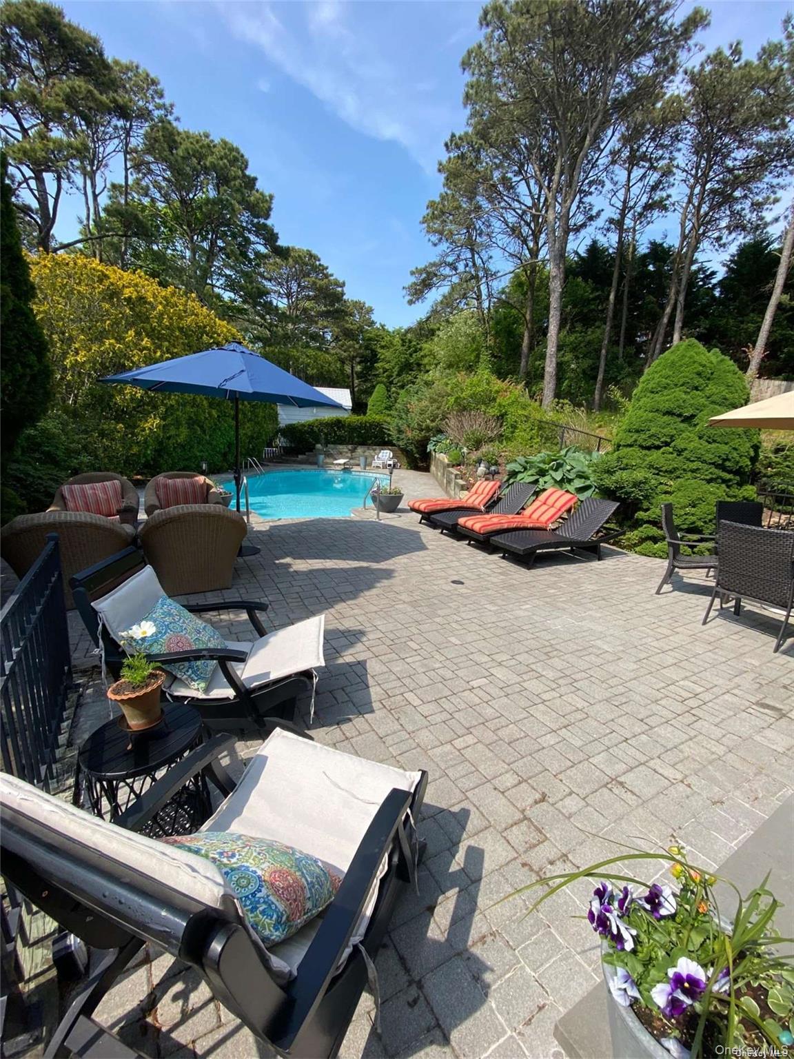 2 West Hillover Road Hampton Bays, NY 11946 - Photo 23 of 42 a view of a patio with table and chairs under an umbrella