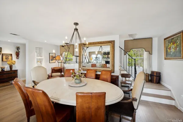 a dining room with furniture a chandelier and wooden floor
