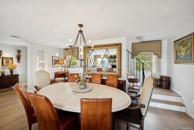 a dining room with furniture a chandelier and wooden floor