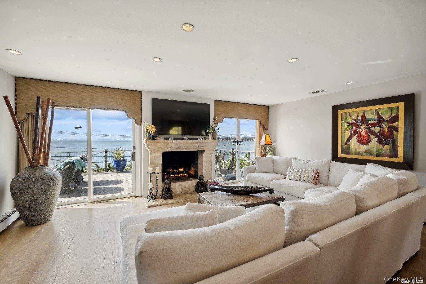 2 West Hillover Road Hampton Bays, NY 11946 - Photo 28 of 42 a living room with furniture a fireplace and a flat screen tv