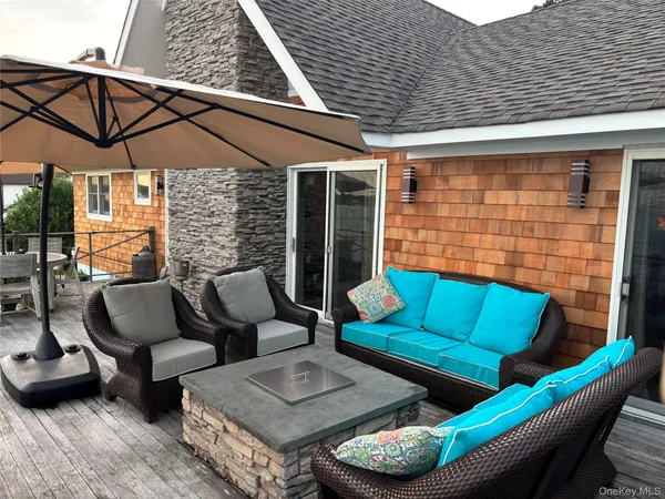 a roof deck with a table and chairs under an umbrella