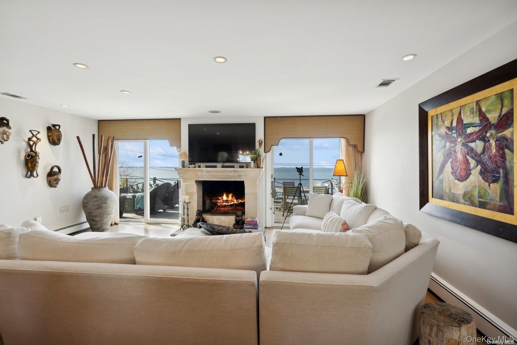 2 West Hillover Road Hampton Bays, NY 11946 - Photo 8 of 42 a living room with furniture a flat screen tv and a fireplace