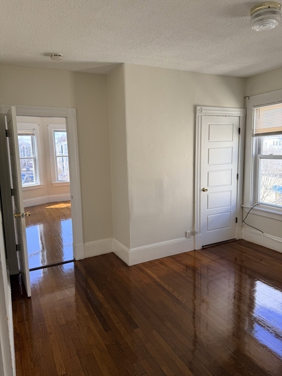 832 Washington Street, Unit 3 Boston, MA 02124 - Photo 12 of 14 an empty room with wooden floor and windows