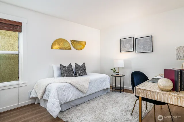 a bedroom with a bed and a potted plant on table
