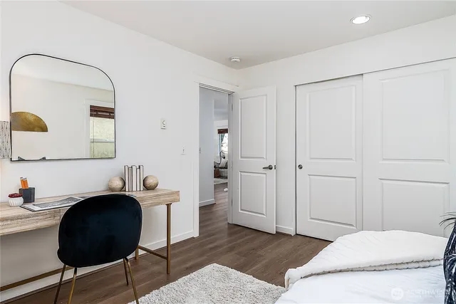 a bathroom with a granite countertop sink a toilet a mirror and bathtub