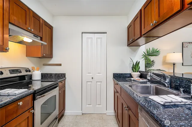 a kitchen with stainless steel appliances granite countertop a sink stove and cabinets