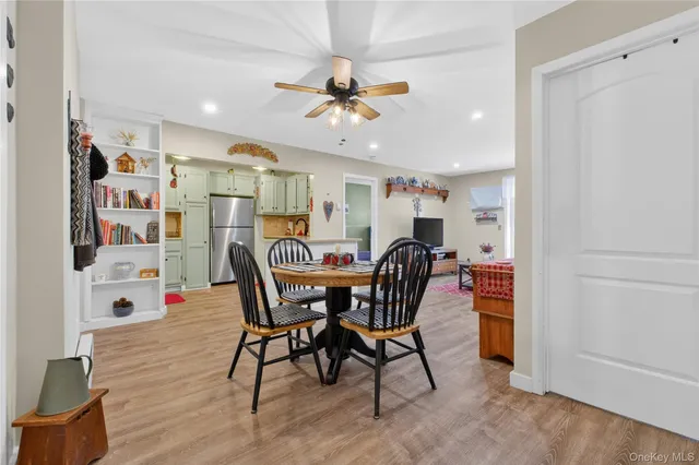 a view of a dining room with furniture and a chandelier fan