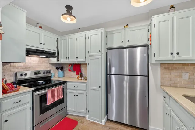 a kitchen with refrigerator a stove and cabinets
